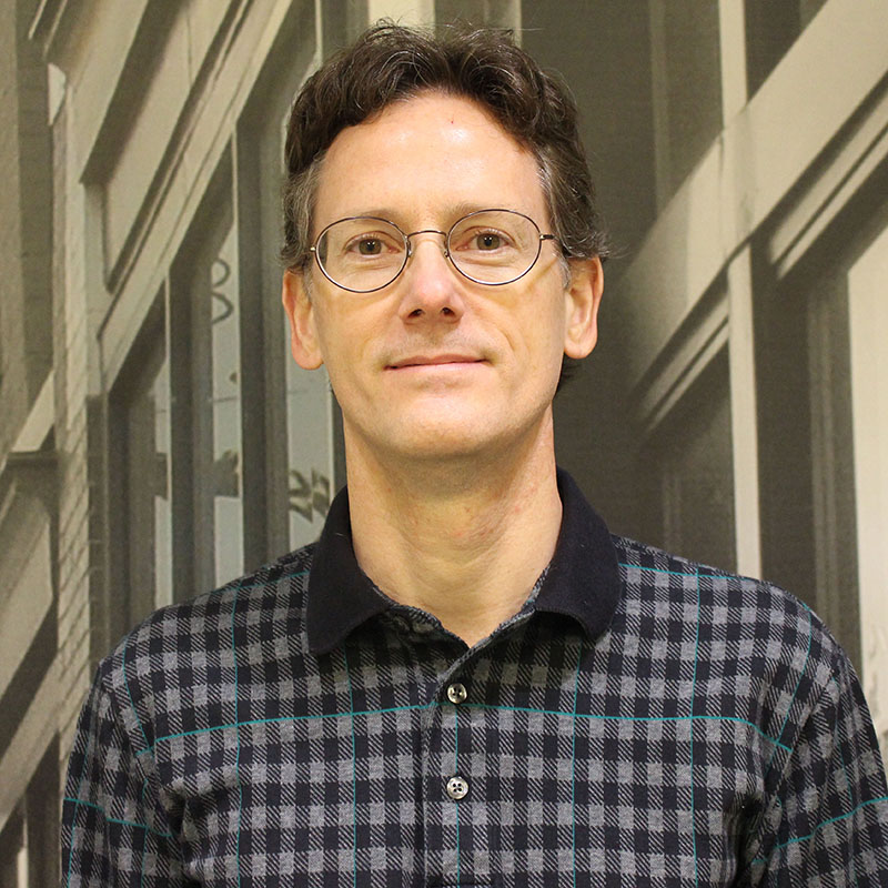 A man wearing glasses and a patterned polo shirt