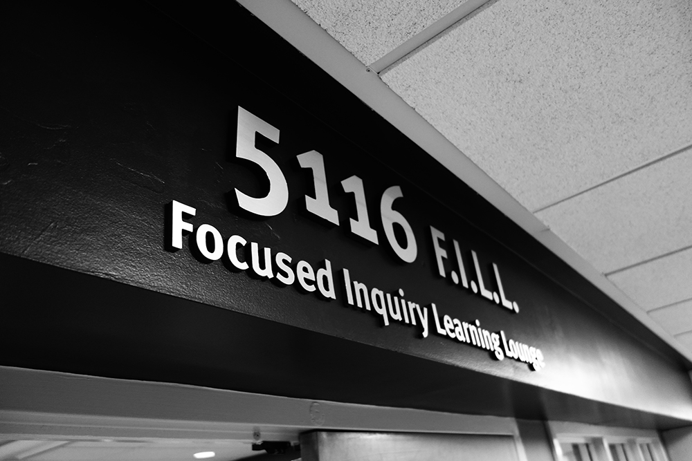 The Focused Inquiry Learning Lounge Sign displayed in black and white