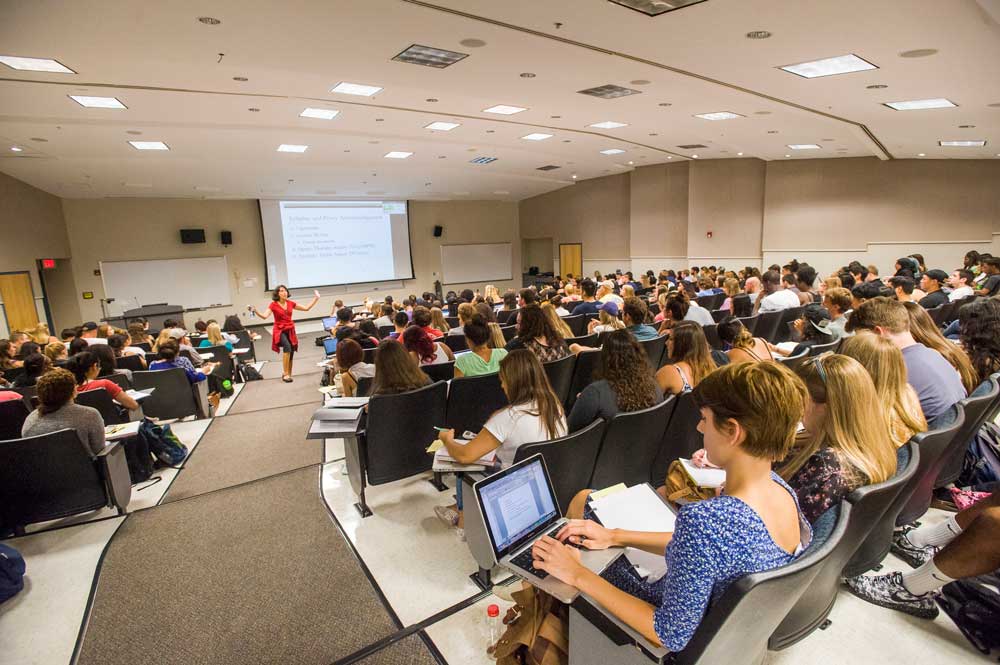 A class full of students take notes during a lecture