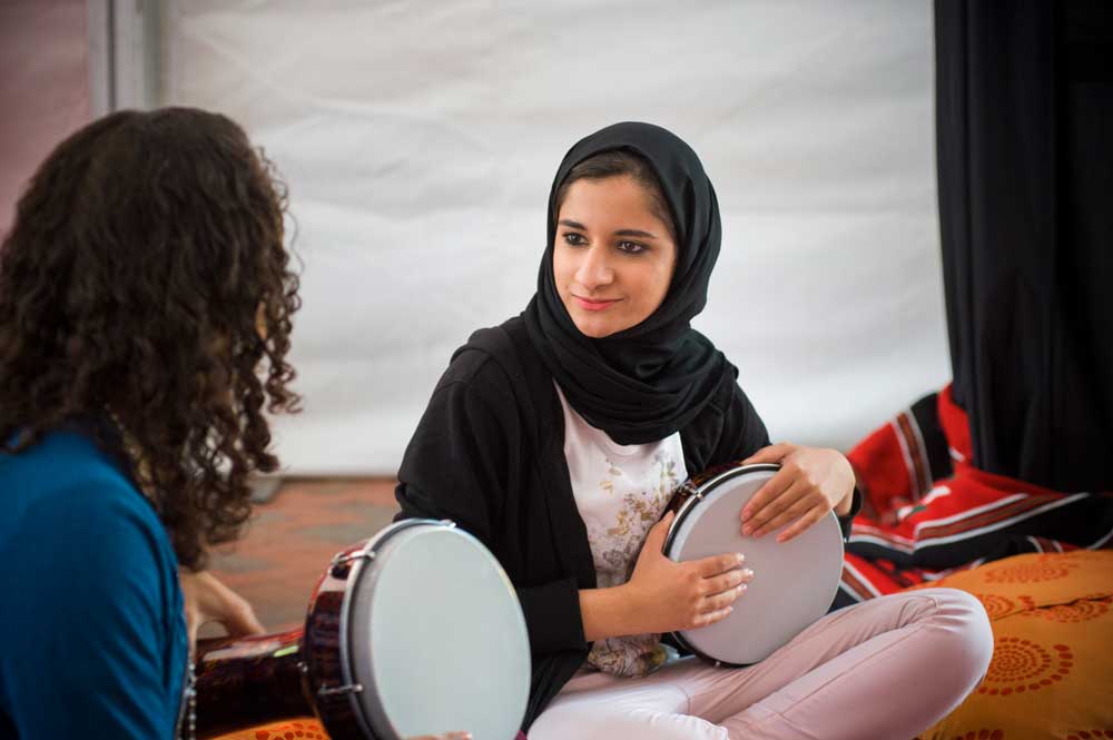 A student performs a drum piece from her native country